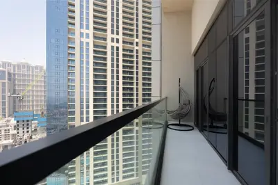 a balcony with chairs and a view of a city at KeyRock Luxury 2BR Apartment with City Views in Dubai