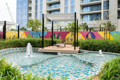 a pool with two fountains in front of a building at Keyrock Living - Elevated Luxury in Business Bay in Dubai