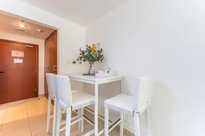 a dining room with a table and white chairs at HAVN - Studio in Downtown, 10mins to Dubai Mall in Dubai