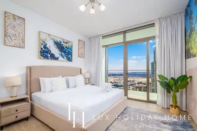 a bedroom with a bed and a large window at LUX The Creek Palace Residence Suite in Dubai