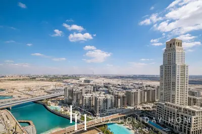 an aerial view of a city with a tall building at LUX The Creek Palace Residence Suite in Dubai