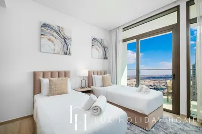 two beds in a room with a window at LUX The Creek Palace Residence Suite in Dubai