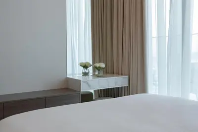 a bedroom with a bed and a table with flowers on it at Keyrock Living - Binghatti Canal Luxury Stay in Dubai