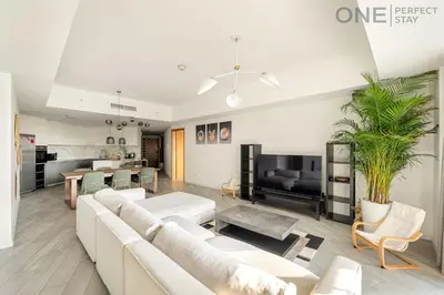 a living room with a white couch and a tv at Stylish & Modern 3BR Apartment in Marina Stunning Views in Dubai