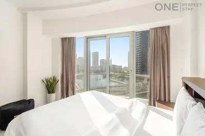 a bedroom with a white bed and a large window at Stylish & Modern 3BR Apartment in Marina Stunning Views in Dubai