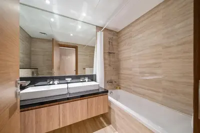 a bathroom with a tub and a sink and a mirror at Stylish 2BR Fully Furnished Unit at Business Bay in Dubai