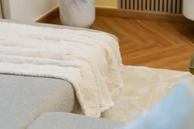 a blanket sitting on the edge of a bed at Luxury 3 bedroom with Stunning Full Marina View in Dubai in Dubai
