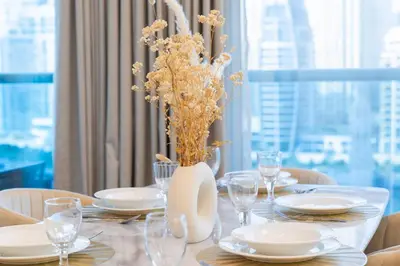 a dining table with a vase of flowers on it at Luxury 3 bedroom with Stunning Full Marina View in Dubai in Dubai