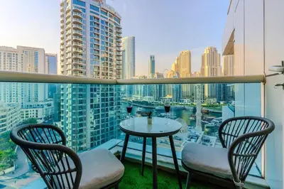 a balcony with a table and chairs and a view of a city at Luxury 3 bedroom with Stunning Full Marina View in Dubai in Dubai