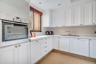 a white kitchen with white cabinets and a sink at GuestReady - Downtown oasis with Burj Khalifa view in Dubai
