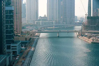 a bridge over a river in a city with buildings at Panoramic! Burj Khalifa and Canal View! in Dubai