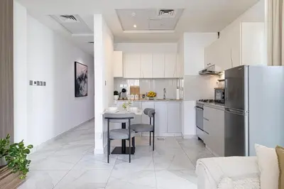 a kitchen with a table and a refrigerator at Panoramic! Burj Khalifa and Canal View! in Dubai
