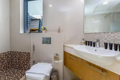 a bathroom with a sink and a toilet and a mirror at Burj Khalifa View - 1BR in Bellevue Tower 2, Downtown - Allsopp & Allsopp in Dubai