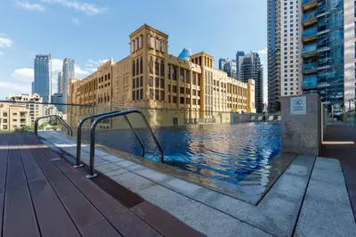 a swimming pool in the middle of a city with buildings at Burj Khalifa View - 1BR in Bellevue Tower 2, Downtown - Allsopp & Allsopp in Dubai