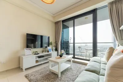 a living room with a couch and a tv at HAVN - Studio Apartment in Goldcrest Views, JLT in Dubai
