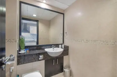 a bathroom with a sink and a toilet and a mirror at HAVN - Studio Apartment in Goldcrest Views, JLT in Dubai