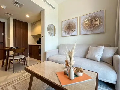 a living room with a couch and a table at Keyrock Living - 1BR at Reva Residence with Lake View in Dubai