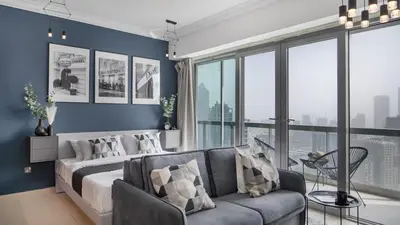 a living room with a bed and a couch at HAVN - Studio in 8 Boulevard, Downtown Dubai in Dubai