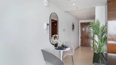 a dining room with a table and chairs and a mirror at HAVN - Studio in 8 Boulevard, Downtown Dubai in Dubai