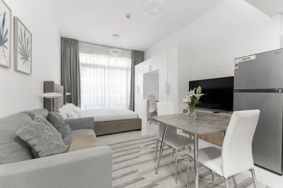 a kitchen and living room with a couch and a table at HAVN - Studio Apartment infront of CircleMall, JVC in Dubai