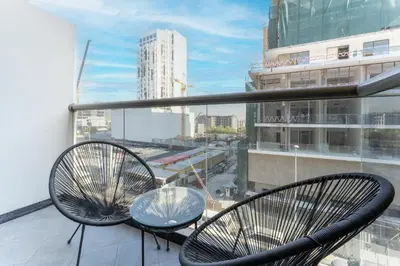 two chairs and a glass table on a balcony at HAVN - Studio Apartment infront of CircleMall, JVC in Dubai