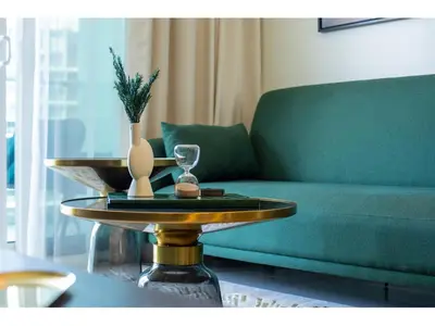 a living room with a green couch and a table at Luxury 1-Bedroom Apartment with Pool, Gym & Balcony in Business Bay in Dubai