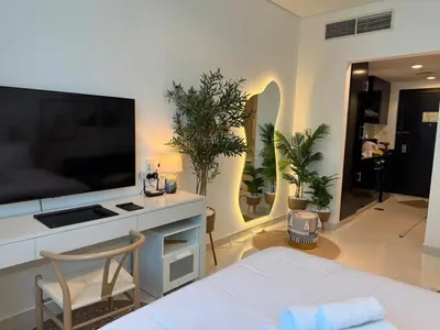 a living room with a bed and a large television at ASHRI HH, Bohemian Style Condo in Downtown in Dubai