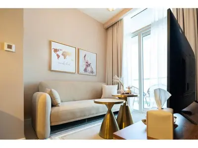 a living room with a couch and a tv at KeyRock Living - Stylish 1BR with Pool Access in Dubai