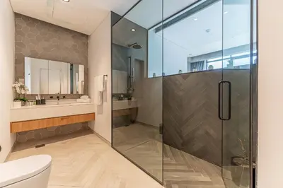 a bathroom with a glass shower and a toilet at HAVN - Studio in KOA Canvas, Access to Nasab Dubai in Dubai