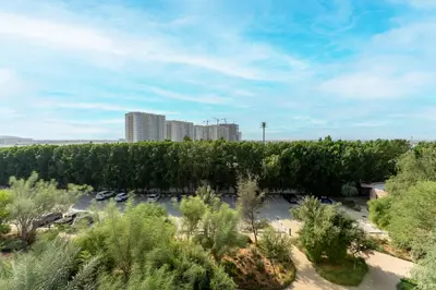an aerial view of a parking lot with trees and buildings at HAVN - Studio in KOA Canvas, Access to Nasab Dubai in Dubai