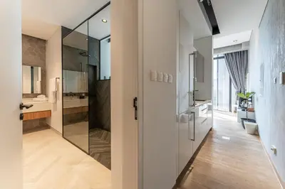 a bathroom with a walk in shower and a glass door at HAVN - Studio in KOA Canvas, Access to Nasab Dubai in Dubai
