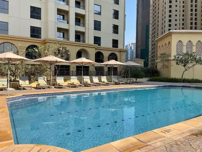 a large swimming pool with chairs and umbrellas at HAVN - Studio in Murjan JBR, 5mins to JBR Beach in Dubai
