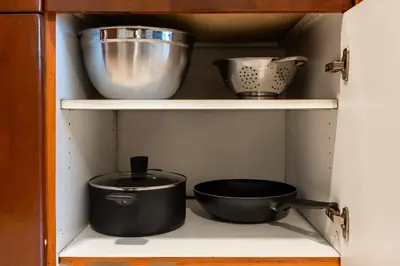 a shelf with pots and pans in a kitchen at Stylish JLT Studio Lakeview Metro FrontMarina in Dubai