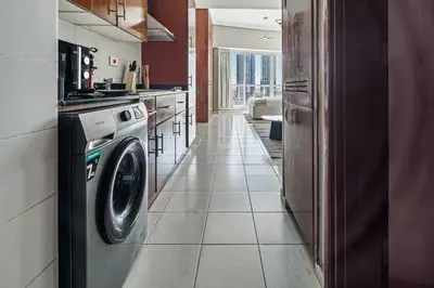 a kitchen with a washing machine in a kitchen at Stylish JLT Studio Lakeview Metro FrontMarina in Dubai