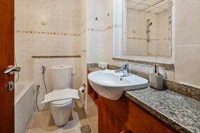 a bathroom with a toilet and a sink and a mirror at Stylish JLT Studio Lakeview Metro FrontMarina in Dubai