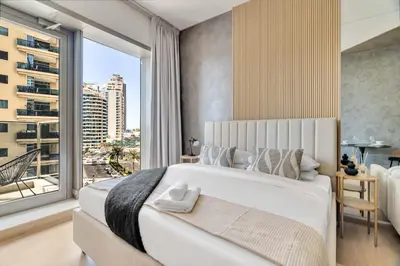 a bedroom with a large bed with a large window at GuestReady - Charming studio in Dubai Marina in Dubai