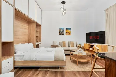 a bedroom with a bed and a living room at Studio APT with Pool, Gym, Squash and Badminton Courts in Dubai