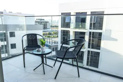 two chairs and a table on a balcony at Bloomfields Modern 2br Azizi Gardens in Dubai