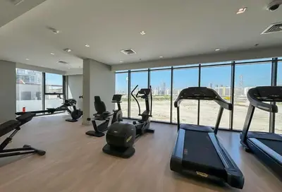 a gym with a bunch of treadmills and elliptical machines at Bloomfields Modern 2br Azizi Gardens in Dubai