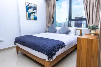 a bedroom with a bed with a blue blanket on it at Bloomfields Modern 2br Azizi Gardens in Dubai