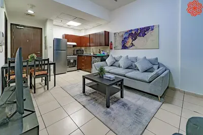 a living room with a couch and a table at Calm 1bdr apartment in JVC in Dubai