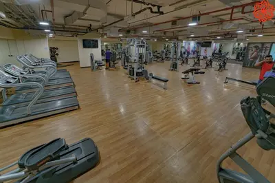 a gym with rows of treadmills and machines at Calm 1bdr apartment in JVC in Dubai