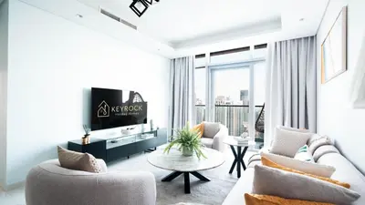 a living room with a couch and a tv at 3BR Paramount Downtown - Burj Khalifa View in Dubai