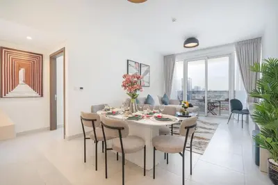 a dining room and living room with a table and chairs at Vogue Al Wasl 1 Residences Near Zabeel Park and World Trade Centre, Two Bedroom Apartment with Balcony offering Dubai Frame and City View, Access to all Amenities, Walkable to Max Fashion Metro Station in Dubai