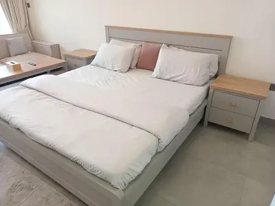 a bed with white sheets and pillows in a room at Studio in Business bay, Metro! in Dubai