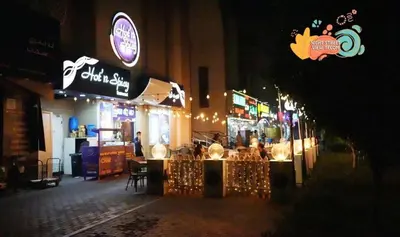 a restaurant with lights on a street at night at Contemporary Room in Barsha Heights Tecom Near ICM Metro in Dubai
