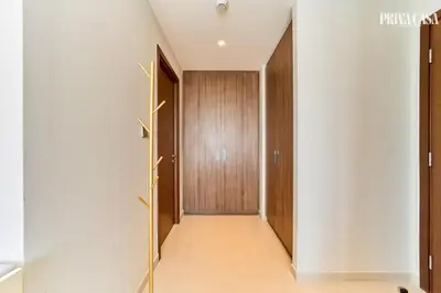 a hallway with white walls and a wooden door at PRIVA CASA - Luxurious 2BR Vida Creek Beach - Beach access in Dubai