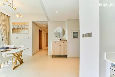 a dining room with a table and a mirror at PRIVA CASA - Luxurious 2BR Vida Creek Beach - Beach access in Dubai