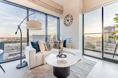 a living room with a white couch and large windows at City Views 1BR Close to Golf Course & Attractions, Binghatti Venus, Jumeirah Village Circle by Deluxe Holiday Homes in Dubai