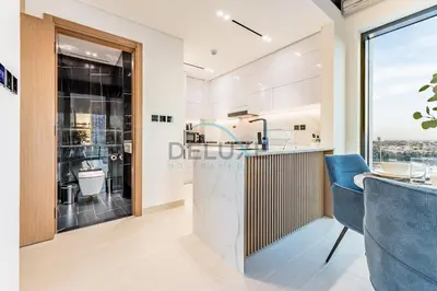 a kitchen and dining area with a view of the city at City Views 1BR Close to Golf Course & Attractions, Binghatti Venus, Jumeirah Village Circle by Deluxe Holiday Homes in Dubai